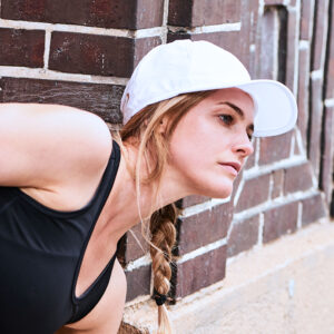 Sportliche Frau trägt kühlendes Basecap von E.COOLINE Farbe weiss