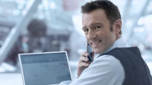 Mann mit E.COOLINE Powercool SX3 Kühlweste vor Laptop am Schreibtisch